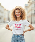 Blonde hübsche Frau mit Locken, trägt ein weißes T-Shirt mit pinken Flamingos drauf