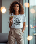 Hübsche Frau mit einem Glas Wein in der Hand und einem weißen T-Shirt mit der Aufschrift "Save Water drink Wine"