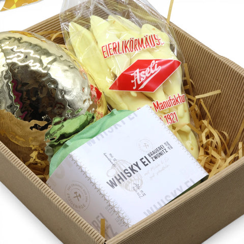 Osternest im Präsentkorb (25x21 cm) mit 4x Zwönitzer Whisky-Eierlikör, Aseli Eierlikör-Mäusen & goldenem Porzellan-Osterei – stilvolles Geschenk zu Ostern.