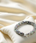 Wunderschönes Perlenarmband Rainbow - White Pearl auf einem cremefarbenen Kissen von der Marke PEARLS®