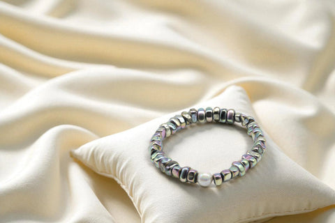 Wunderschönes Perlenarmband Rainbow - White Pearl auf einem cremefarbenen Kissen von der Marke PEARLS®